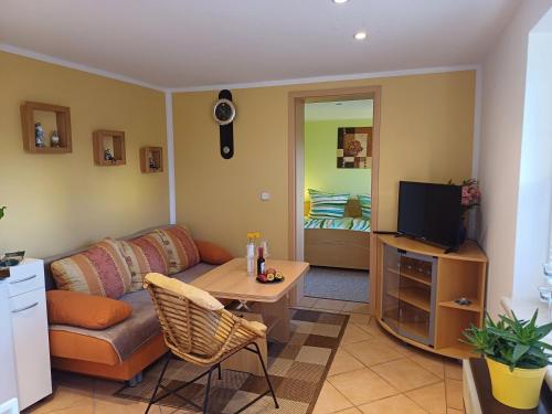 ein Wohnzimmer mit Couch und Fernseher in der Unterkunft Ferienbungalow Jahnke auf Usedom mit Wlan in Zirchow