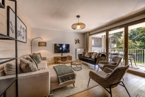 un salon avec un canapé, des chaises et une télévision dans l'établissement White Pearl Apartments, à Chamonix-Mont-Blanc