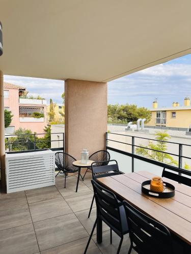 un patio avec tables et chaises sur un balcon dans l'établissement L'échappée, à Bandol