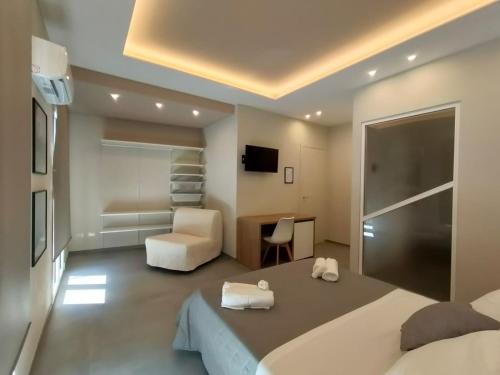 a bedroom with a bed and a chair and a desk at Luma Casa Vacanze Castelbuono in Castelbuono