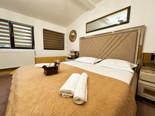 a bedroom with a large bed with towels on it at Golden Escape - Charming Studio in Prime Location in Craiova