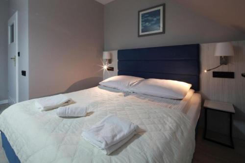 a bedroom with a large white bed with towels on it at Willa Nova in Wisła