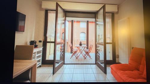 a living room with a door open to a balcony at Mimosa in Acquaseria