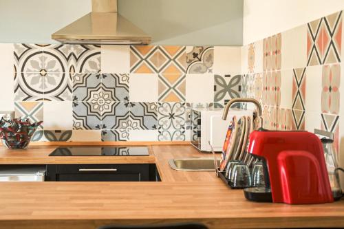 a kitchen with a red faucet and tiles on the wall at Frally's dream in Catania