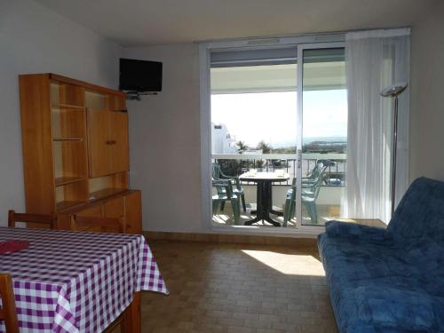 un salon avec un canapé, une table et une fenêtre dans l'établissement Studio cabine 4 pers - Plage à 50m - Parking privé - FR-1-328-89, à La Grande Motte