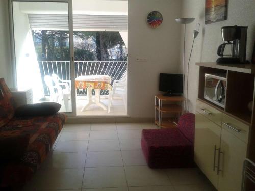- un salon avec une porte s'ouvrant sur une terrasse dans l'établissement Studio Calme avec Loggia, à 600m de la Plage et Proche Commerces - FR-1-328-93, à La Grande Motte