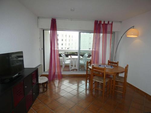 un salon avec une table, des chaises et une télévision dans l'établissement Studio Cabine - Loggia Sud - Proche Plage et Commerces - 4 Pers - Parking Privé - FR-1-328-104, à La Grande Motte