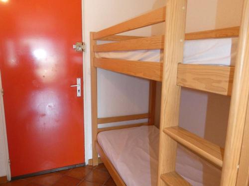 Cette chambre comprend 2 lits superposés et une porte rouge. dans l'établissement Studio Cabine - Loggia Sud - Proche Plage et Commerces - 4 Pers - Parking Privé - FR-1-328-104, à La Grande Motte
