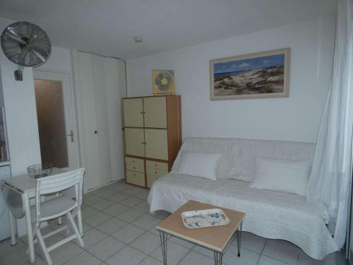 un salon avec un canapé et une table dans l'établissement Studio Cabine Moderne avec Piscine, Proche Plage, Calme, Vert, Tout Confort - La Grande Motte - FR-1-328-105, à La Grande Motte