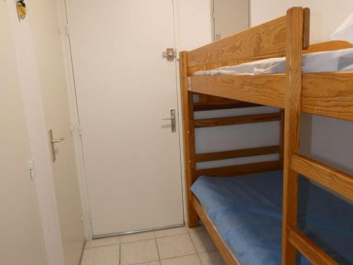 - deux lits superposés dans une chambre avec une porte dans l'établissement Studio Cabine Moderne avec Piscine, Proche Plage, Calme, Vert, Tout Confort - La Grande Motte - FR-1-328-105, à La Grande Motte