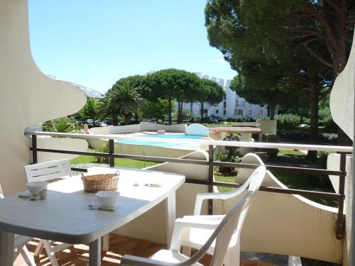 d'un balcon avec une table, des chaises et une piscine. dans l'établissement Studio Cabine avec Piscine, Loggia et Parking à 150m de la Plage, La Grande-Motte - FR-1-328-123, à La Grande Motte