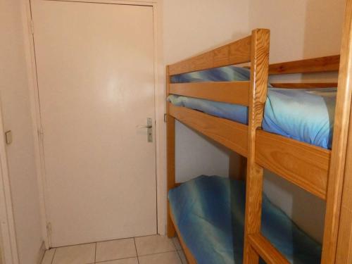 Cette chambre dispose de lits superposés avec 2 lits superposés et une porte. dans l'établissement Studio Cabine avec Piscine, Loggia et Parking à 150m de la Plage, La Grande-Motte - FR-1-328-123, à La Grande Motte
