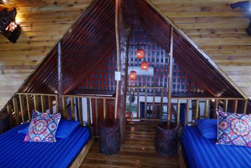 two beds in a room with wooden walls at Mai Pen Rai Bungalows in Than Sadet Beach