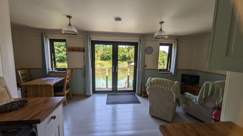 a kitchen and living room with a door to a yard at Lynstone Lakes in Bude