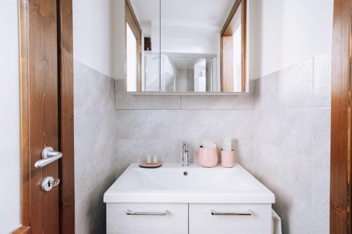 Saint MarcelにあるAosta Holiday Apartments - La Plantazの白い洗面台と鏡のあるバスルーム