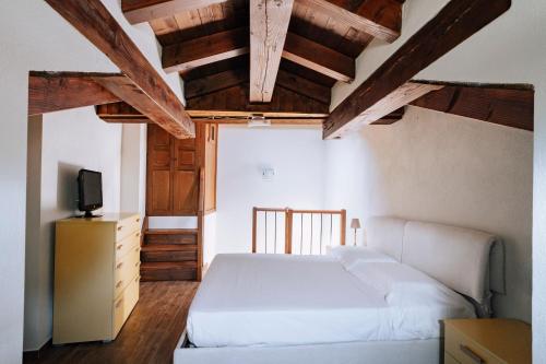 Saint MarcelにあるAosta Holiday Apartments - La Plantazの白いベッドと木製の天井が備わるベッドルーム1室が備わります。