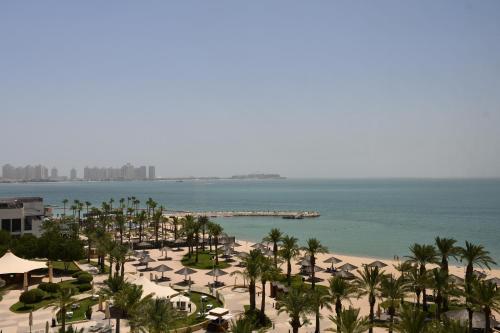 ドーハにあるInterContinental Doha Beach & Spa by IHGのヤシの木と海の景色を望む