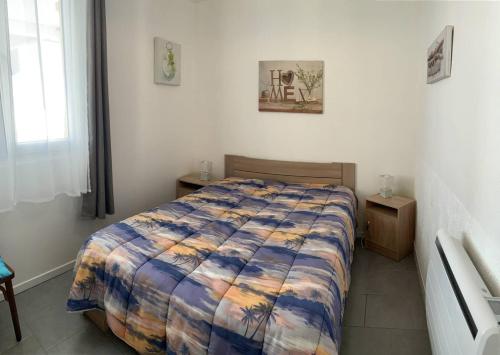 une chambre avec un lit avec une couette colorée dans l'établissement La frégate marine de St Hilaire, à La Parée Preneau