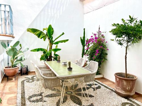 a table and chairs in a room with plants at La Fonda Heritage Hotel Luxury, Relais & Châteaux in Marbella