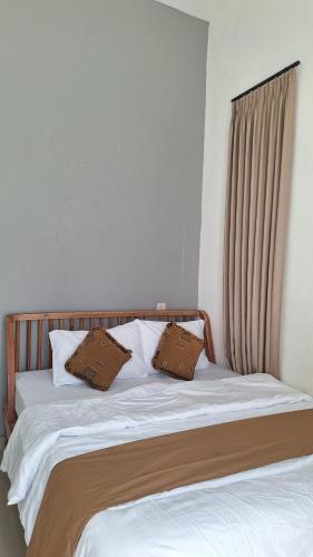 a bed with two pillows on top of it at Tobacco Villa in Jember