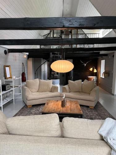 a living room with two couches and a table at Cottage 1909- Close to Helsingborg in Helsingborg