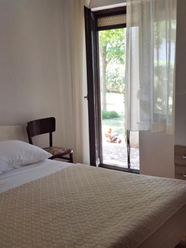 a bedroom with a bed and a large window at APARTMAN LUCIA in Ražanac