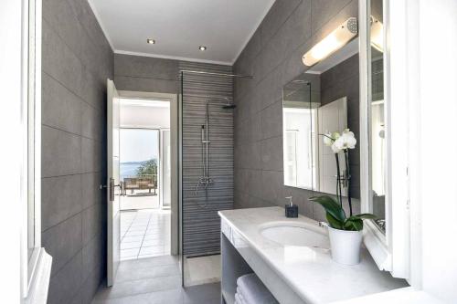 een badkamer met een wastafel en een spiegel bij Villa Giovannina in Perama