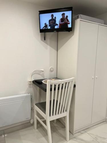 - une télévision murale au-dessus d'un bureau avec une chaise dans l'établissement Studio indépendant Disney-Vallée, à Gretz-Armainvilliers
