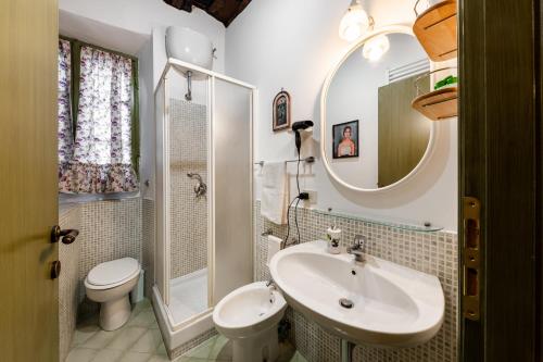 a bathroom with a sink and a toilet and a mirror at Green Home in Ronciglione