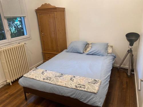 une chambre avec un lit et une commode dans l'établissement Charmante Maison Familiale près de Paris, à Drancy