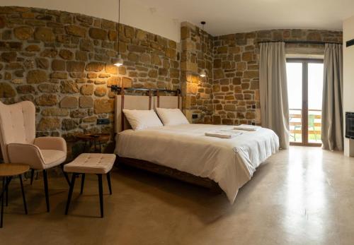 a bedroom with a bed and a brick wall at Άνδηρο in Synikia Mesi Trikalon