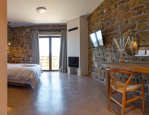 a bedroom with a bed and a stone wall at Άνδηρο in Synikia Mesi Trikalon
