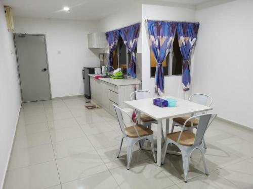 a kitchen with a table and chairs in a room at Marina Island Couple Home Stay in Lumut