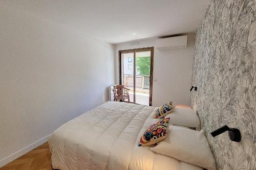 une chambre blanche avec un lit et une fenêtre dans l'établissement Henri Camille Real Estate- Palm Beach -Premium one bedroom with big terrace, à Cannes