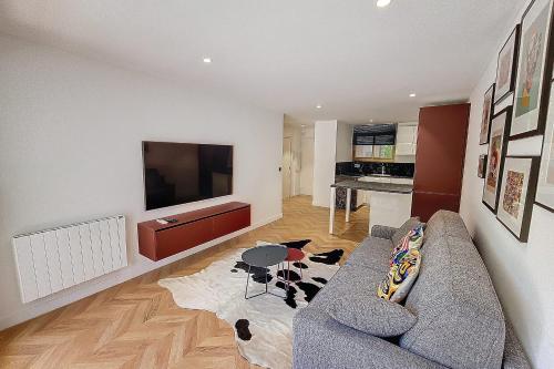 un salon avec un canapé et une télévision dans l'établissement Henri Camille Real Estate- Palm Beach -Premium one bedroom with big terrace, à Cannes