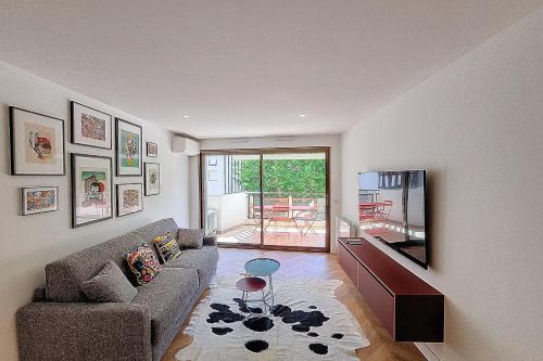 un salon avec un canapé et une télévision dans l'établissement Henri Camille Real Estate- Palm Beach -Premium one bedroom with big terrace, à Cannes