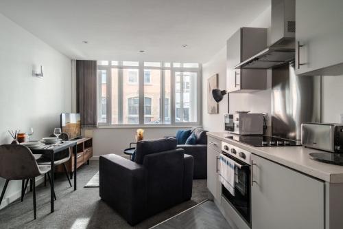 a kitchen and living room with a couch and a table at Central Preston Modern 1 Bedroom Apartment in Preston