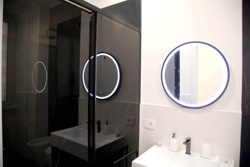 a bathroom with two mirrors and a sink at Domus Olympia in Rome