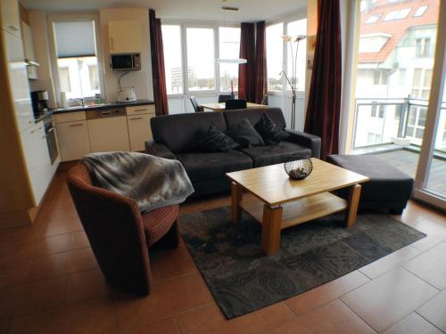 een woonkamer met een bank en een tafel bij Meerblick 9 - Großenbrode in Großenbrode