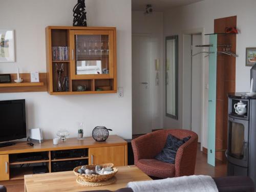 een woonkamer met een tafel, stoelen en een televisie bij Meerblick 9 - Großenbrode in Großenbrode