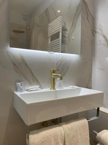 a white bathroom with a sink and a mirror at Hotel Maxim Axial in Florence