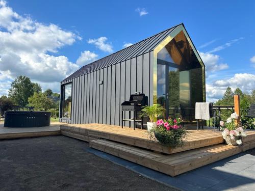 a house with a large window and a wooden deck at Gold LUX in Kuldīga