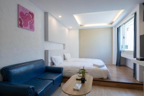 a living room with a couch and a bed at 日日藍旅市區民宿 in Hualien City