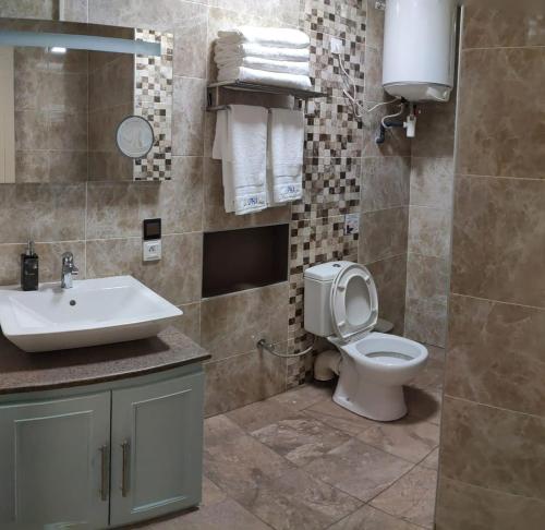 Un baño con un inodoro blanco y un lavabo. en Appartement hôtel de luxe 974, en Antananarivo
