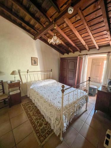 a bedroom with a white bed with a wooden ceiling at Casa de São Cucufate - Casa de Campo in Vila de Frades