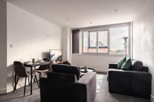 a living room with a couch and a table at 1 Bed Modern Central Preston Apartment in Preston