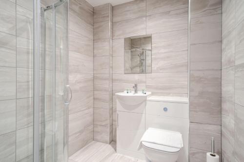 a white bathroom with a toilet and a shower at 1 Bed Modern Central Preston Apartment in Preston