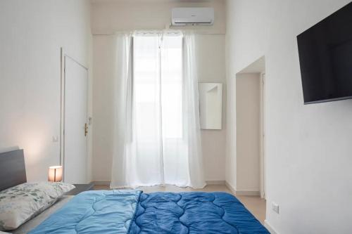 a bedroom with a blue bed and a large window at Spagno li's House in Naples