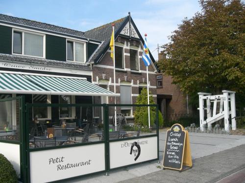 un restaurante con una señal frente a un edificio en Bed & Breakfast d'Ouwe Smidse, en Kamperland