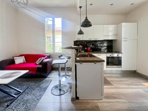Il comprend une cuisine et un salon avec un canapé rouge. dans l'établissement Proche promenade des anglais et de la mer, à Nice